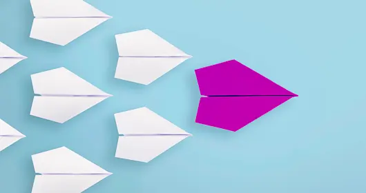 Several paper airplanes following the leader plane