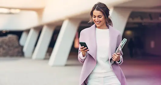 Woman walking while checking cell phone