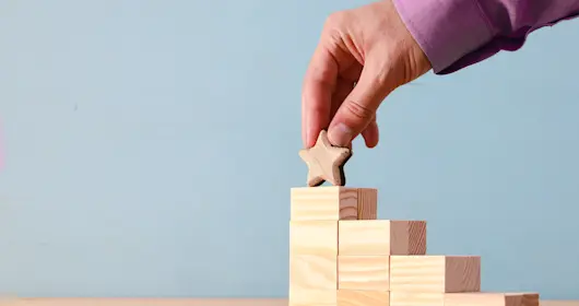 Blocks stacked up like stairs with star on top stair
